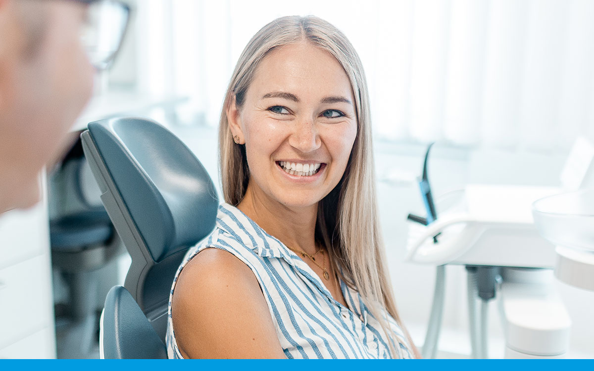 Frau lächelt auf dem Zahnarztstuhl in der Praxis am Weißen Turm in Darmstadt.